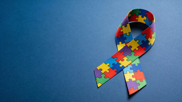 Colorful autism awareness ribbon on blue background  