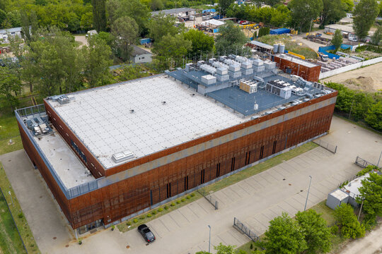 Aerial view of moder AI compute hub featuring modern industrial architecture with a rusted metal facade and rooftop HVAC systems in Warszawa, Wojewodztwo mazowieckie, Poland.