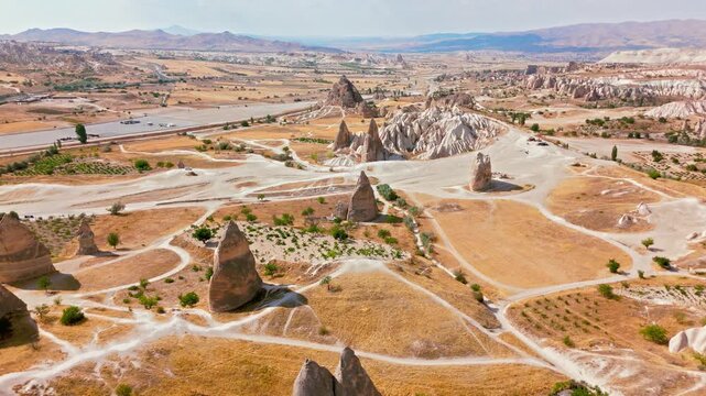 Drone view of Cappadocia, Turkey valley roads. Curving tracks weave through rock formations and dry plains in a classic travel landscape.