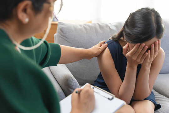 Young woman in a mental therapy session talking with a psychologist in the office.