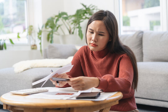 Women calculating her income and feeling anxious about paying the due for her debts.