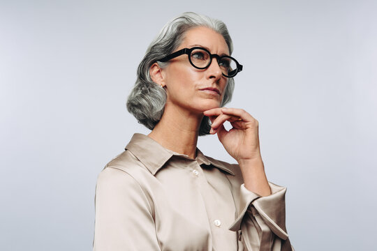 Woman in studio touching chin and thinking