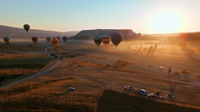 Aerial view of Love Valley in Cappadocia during golden hour. Sunlit trails and rocky terrain reveal the natural beauty of the valley.