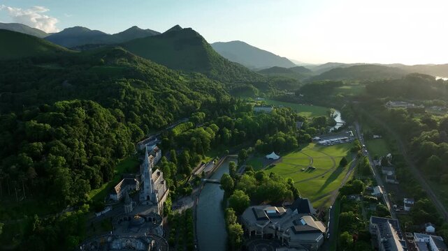 Aerial view of Lourdes Sanctuary basilica beside the Gave river in green Pyrenees valley