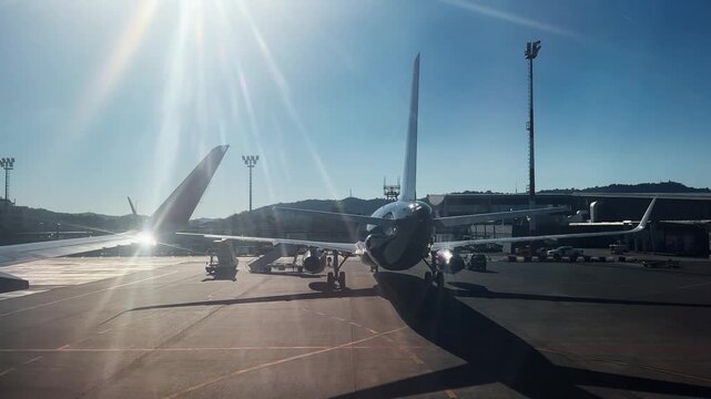 Arrival pov with airplane parked tarmac under bright sunlight during early morning at Mother Teresa airport in Tirana, Albania