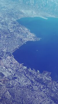 Stunning plane pov aerial shot of Thessaloniki in Greece,  sprawling city nestled around a picturesque bay, vertical video