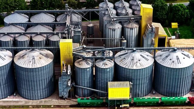 High-angle view of industrial grain silos and cargo train cars
