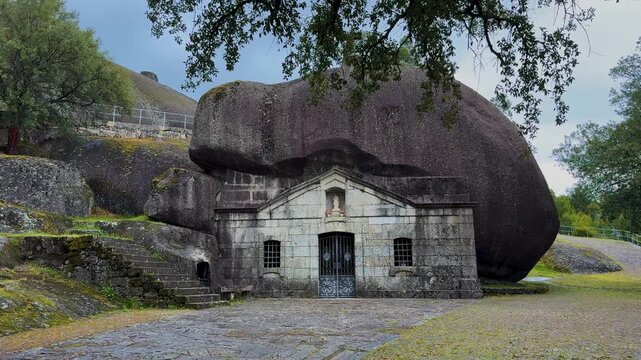 The Santuario de Nossa Senhora da Lapa, a stone chapel constructed beneath a massive granite boulder in Soutelo, Portugal.
