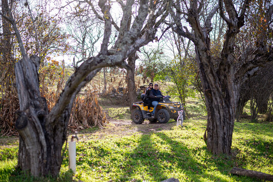 People riding a quad bike with dog through rural nature