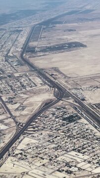 Aerial viewpoint of desert highway traffic and city complex urban infrastructure in Abu Dhabi, UAE, vertical video