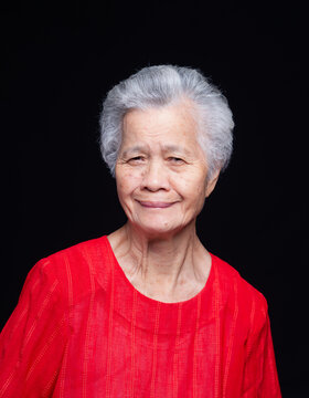 Senior Woman Portrait Wearing Red Shirt on Dark Background