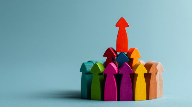 Colorful wooden arrow figures pointing upward, symbolizing growth, leadership, teamwork, and success, arranged on light blue background with creative and motivational concept