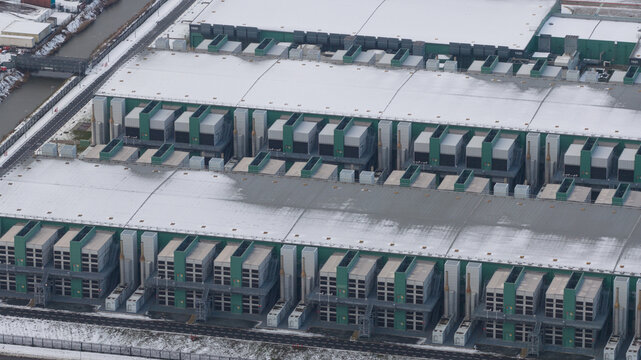 Aerial view of the massive data center complex with snow-covered rooftops and industrial cooling systems Middenmeer, North Holland, Netherlands.