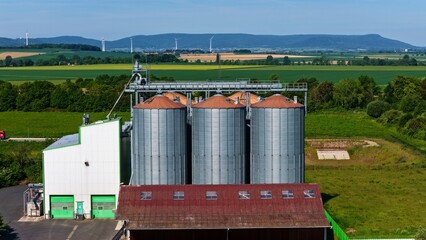 Aerial View of Modern Grain Silos Farm with Wind Turbines in Germany © Maik
