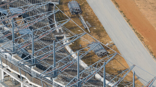 Aerial view of Chaiyaphruek Pattaya Stadium showing the complex steel roof structure, grandstands, and construction materials on the ground Muang Pattaya, Chang Wat Chon Buri, Thailand.