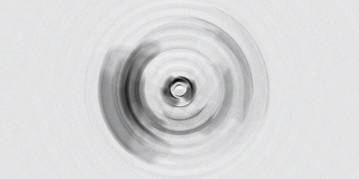 Circular ripple effect background with soft gray monochromatic tones and central light flare creating calm peaceful design.