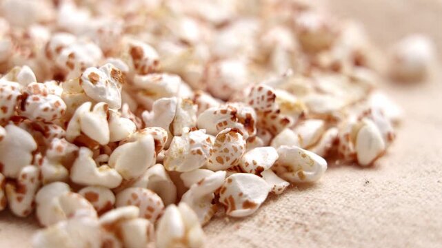 White crunchy puffed buckwheat grains on rough fabric. Fitness nutrition concept. Rotation