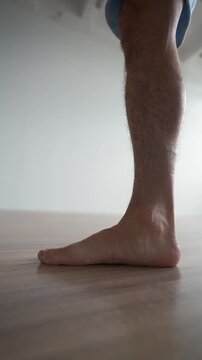 Barefoot person performing foot strengthening exercise to improve arch support and prevent flat feet. Concept of foot health and rehabilitation. Vertical video