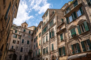 Fototapeta premium Old European buildings with green shutters and sunlit courtyards under blue sky