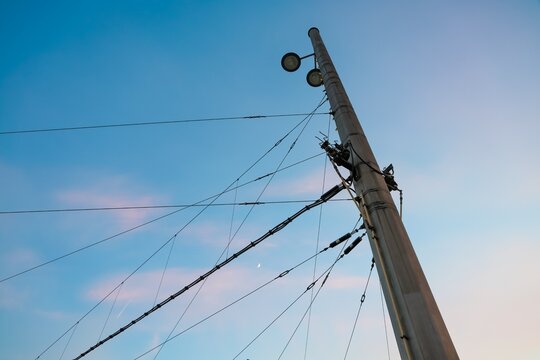 Utility pole with power lines and crescent moon in sky