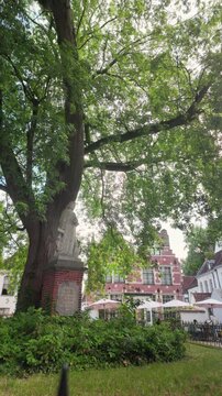 Historic UNESCO Courtrai beguinage reveal shot showing a vertical upward movement unveiling the tranquil heritage courtyard and iconic architecture.