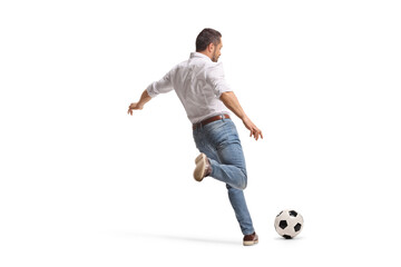 Obraz premium Man in casual clothes kicking a football