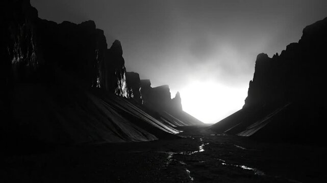 Epic monochrome canyon landscape with bright light illuminating the end of a narrow valley, a cinematic visual scene