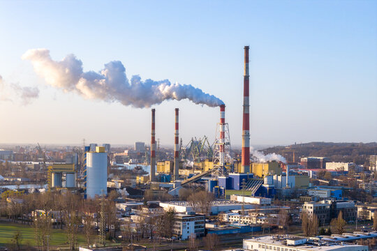 Aerial view of Elektrocieplownia EC-2 power plant with tall chimneys emitting white smoke over the industrial district and city skyline Gdansk, Pomeranian Voivodeship, Poland.