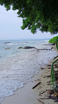 A relaxing vertical shot of gentle ocean waves rolling onto the sandy shores of Radhanagar Beach on Havelock Island (Swaraj Dweep), Andaman and Nicobar Islands.