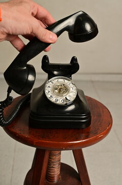 Hand holding an old telephon with rotary dial