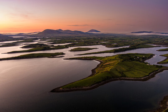 Aerial sunset view over Clew Bay near Westport, County Mayo, Ireland. Scenic Atlantic bay with drumlin islands and mountain silhouettes on the Wild Atlantic Way.