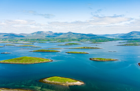 Morning aerial view of the islands of Clew Bay in County Mayo, Ireland, with calm blue water and vivid green shores. A serene coastal landscape on Irelands west coast.