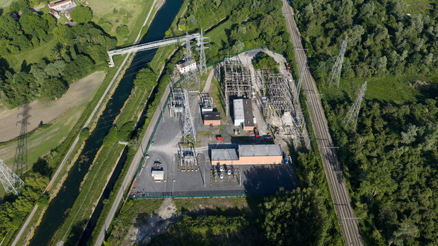 Aerial view of Elia TS Ville sur Haine electrical substation with high-voltage towers and transformers near a canal and railway line in Mons, Region wallonne, Belgium.