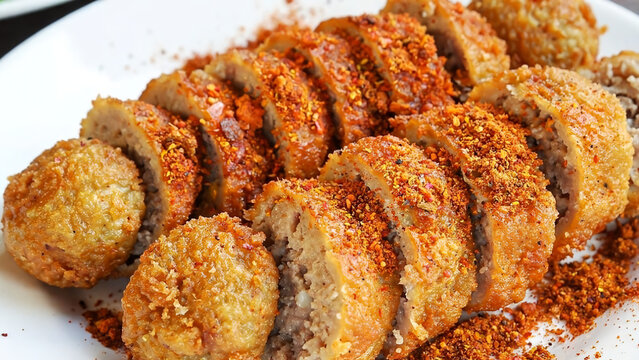 Crispy sliced roll meatball bakso bakar covered in abundant spicy chili powder seasoning