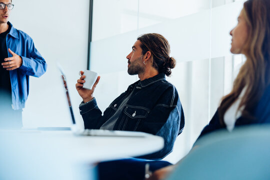 Colleagues engaged in focused discussion during office meeting