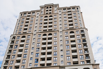 Naklejka premium Symmetrical residential facade with repetitive arches and aligned balconies, highlighting proportion, rhythm and classicalinspired modern design for architectural use