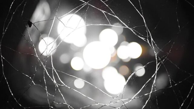 Abstract shot of broken glass framing blurry lights creating a unique bokeh effect with a dark background