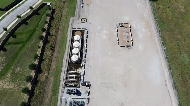 Row tank operations anchor South Arlington service facility near local greenbelts, TX 360 influence zone. Tank surfaces, pipe networks, gravel gradients produce layered mechanical textures, Texas