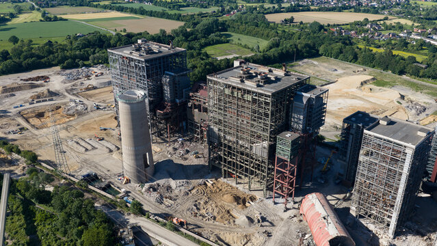 Aerial view of the Kraftwerk Voerde power plant under demolition featuring steel skeletons, concrete towers, and excavators in Voerde, North Rhine-Westphalia, Germany.