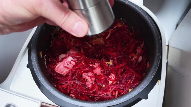 Adding ground pepper to meat and other vegetables in multicooker