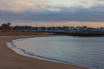 Naklejka premium Curved sandy beach and calm ocean bay at Playa de la Guirra in Fuerteventura