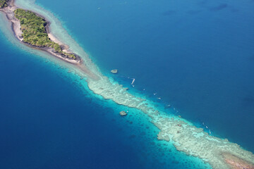 Vue aérienne d'îlot volcanique verdoyant entouré de récif frangeant turquoise à Mayotte © romain