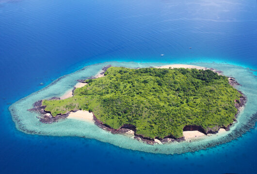 Vue a&eacute;rienne d'&icirc;lot volcanique verdoyant entour&eacute; de r&eacute;cif frangeant turquoise &agrave; Mayotte
