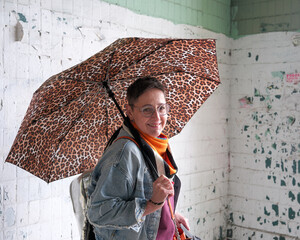 Stylish woman with playful umbrella in urban setting enjoys her day © aviavlad