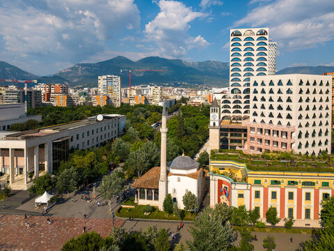 Aerial view of Et'hem Bey Mosque and the Clock Tower surrounded by modern architecture and green trees in Tirane, Tirana County, Albania.