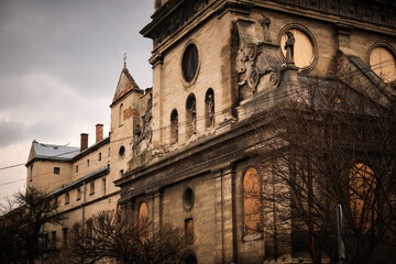 Obraz premium Historic Bernardine church facade with boarded windows and stone statues closeup
