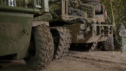 Fototapeta premium Military unmanned ground vehicle (UGV) inside a hangar or field workshop.