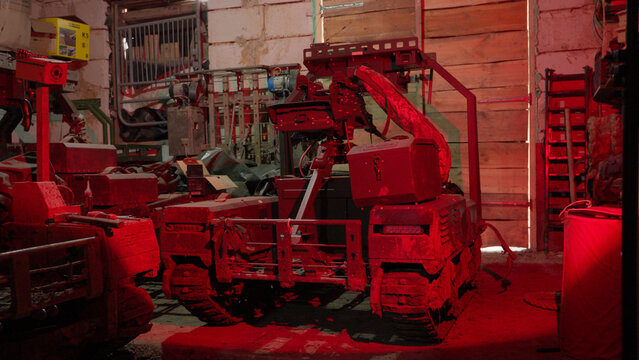 Military unmanned ground vehicle (UGV) inside a hangar or field workshop.