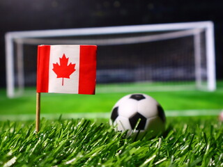 Canadian flag on a soccer field with a ball in front of the goal, representing sports, international competition, and canadian soccer team © Photo Agency
