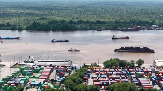 Aerial view of tugboats pulling coal-laden barges near the port